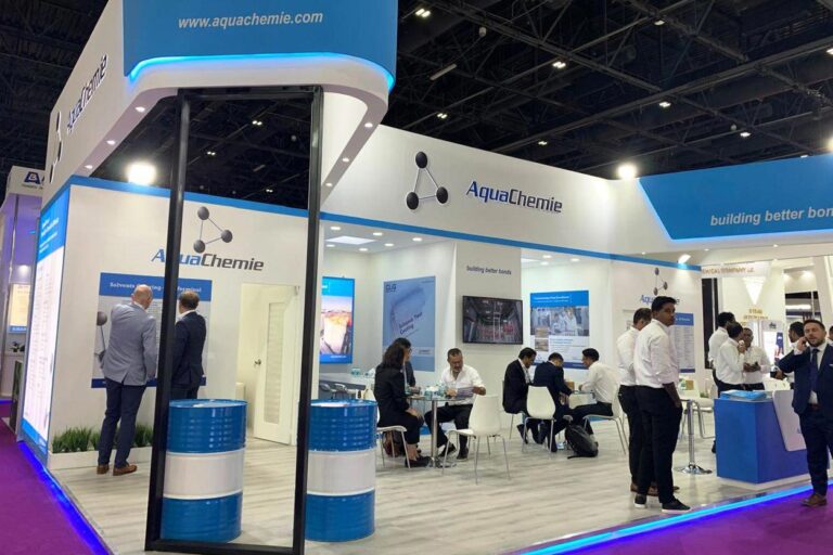 AquaChemie exhibition booth showcasing solutions, with visitors interacting at the event